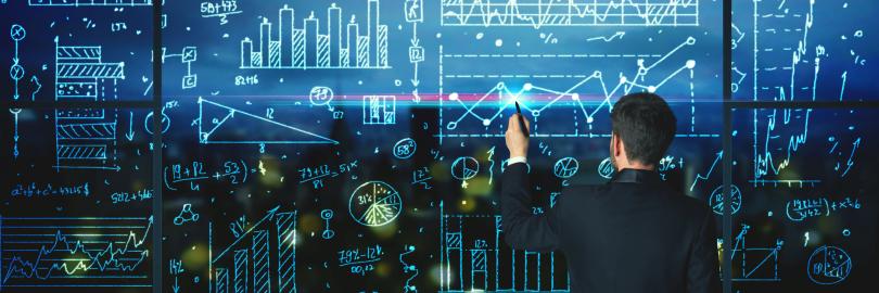 Ein mann steht vor einer Tafel mit vielen Statistiken und Diagrammen