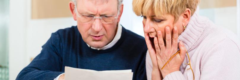 Renterpaar schaut entsetzt auf ein Blatt Papier