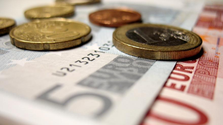 Kleine Euro-Scheine und Münzen liegen aufeinander