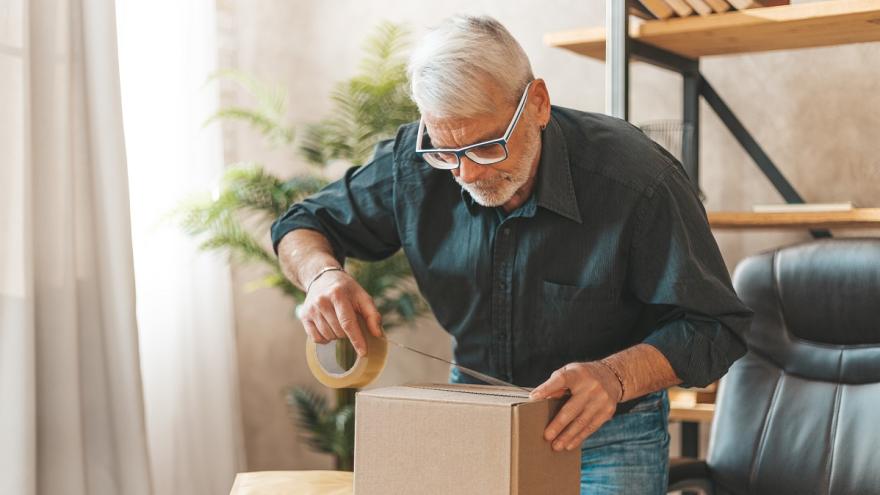 Mann verschließt ein Paket für die Rücksendung