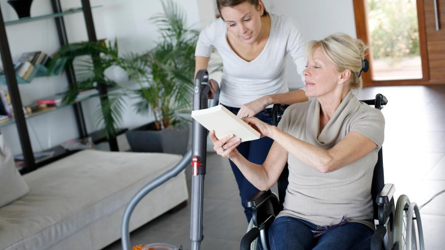 Haushaltshilfe hilft Patientin im Rollstuhl