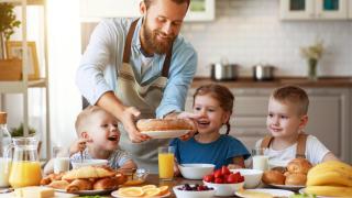 Vater mit kleinen Kindern beim gemeinsamen Essen. (c) JenkoAtaman / AdobeStock